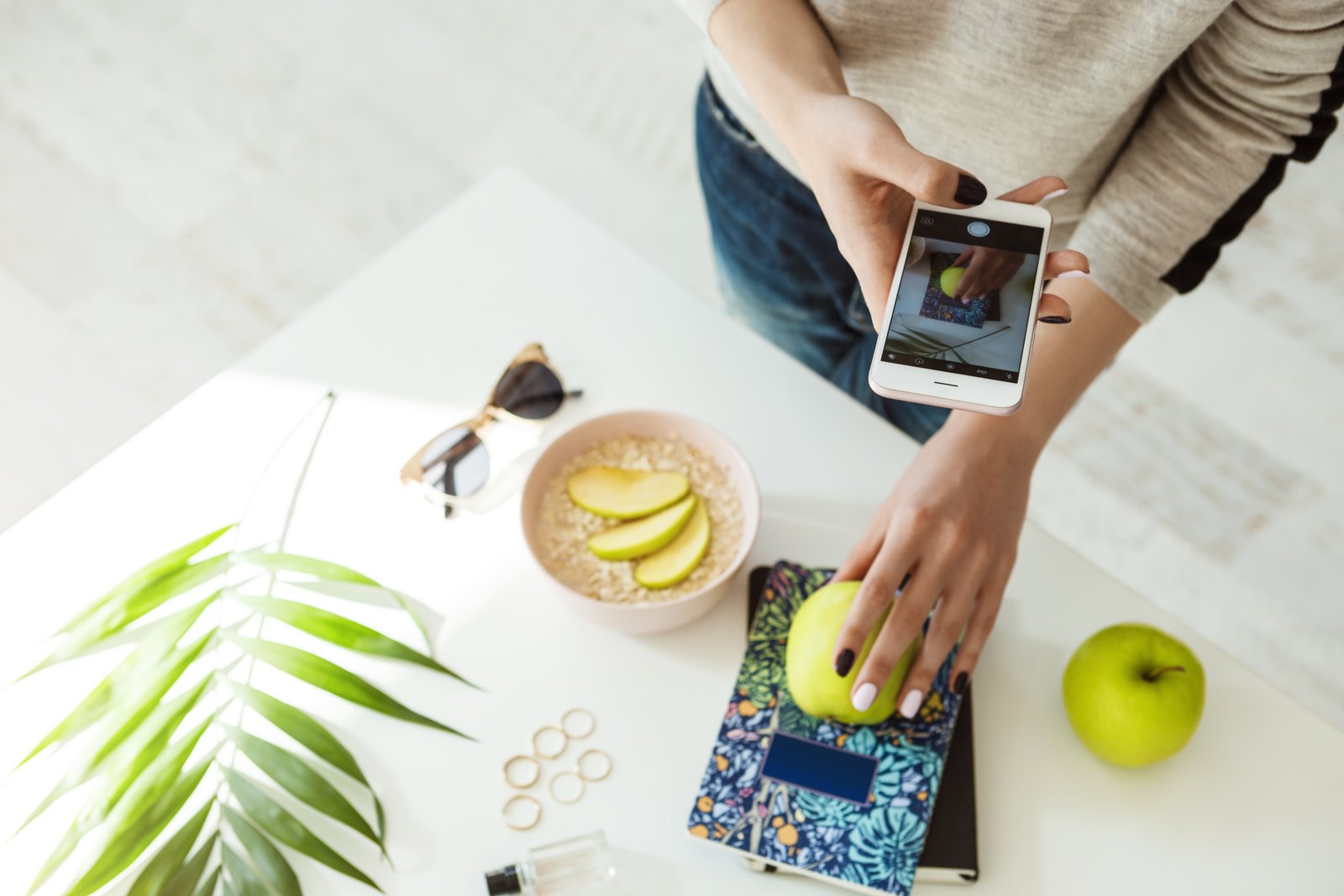 stylish-girl-taking-pictures-with-apple-notebook-whie-table-min